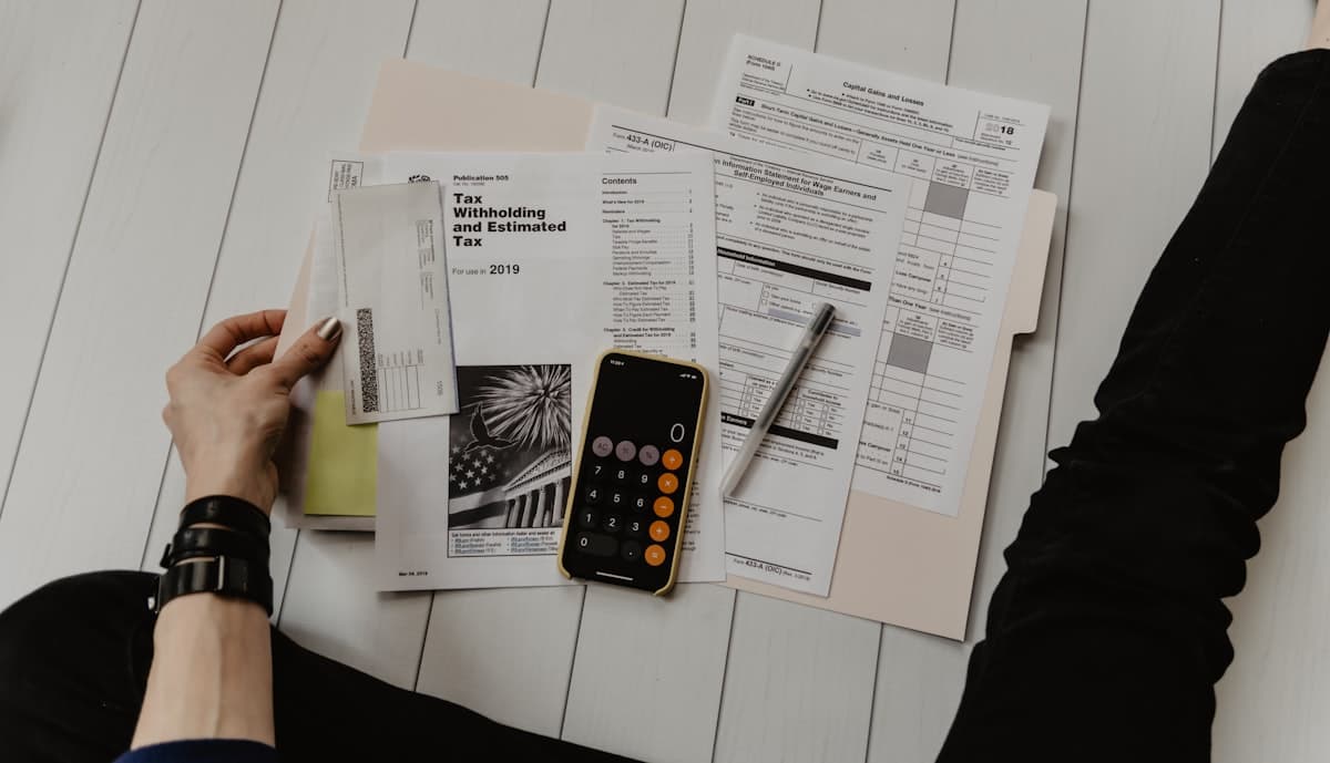 Invoices and a calculator on the desk, the numbers being worked