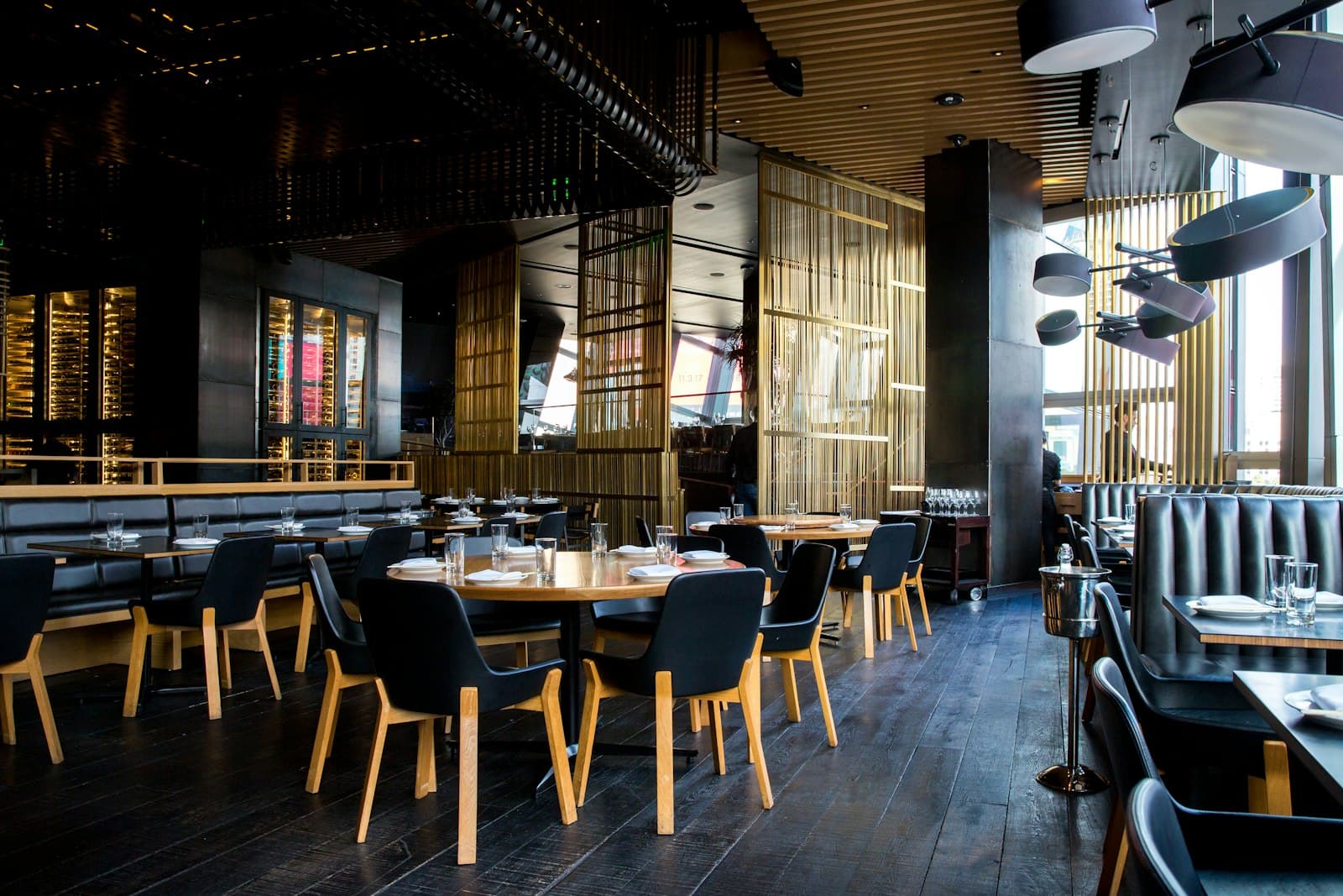 A finished dining room, timber slats and set tables, ready for the first cover